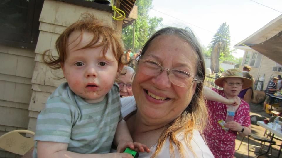 Woman with glasses holding toddler